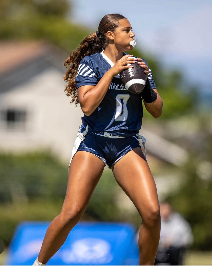 High school quarterback wearing the black female fit wrist coach in a game throwing the ball