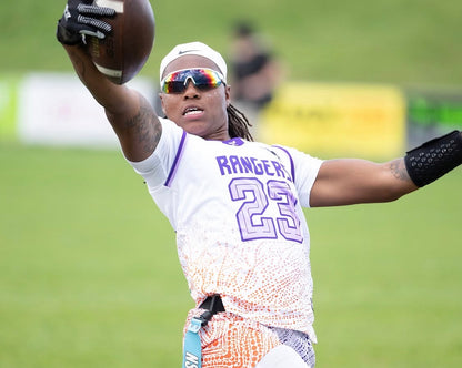 Adult flag football player wearing the black playbook wrist coach while catching a ball in the game