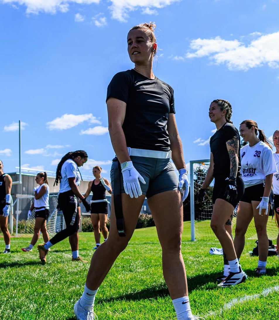 Female athlete wearing the black compression core shirt during flag football practice