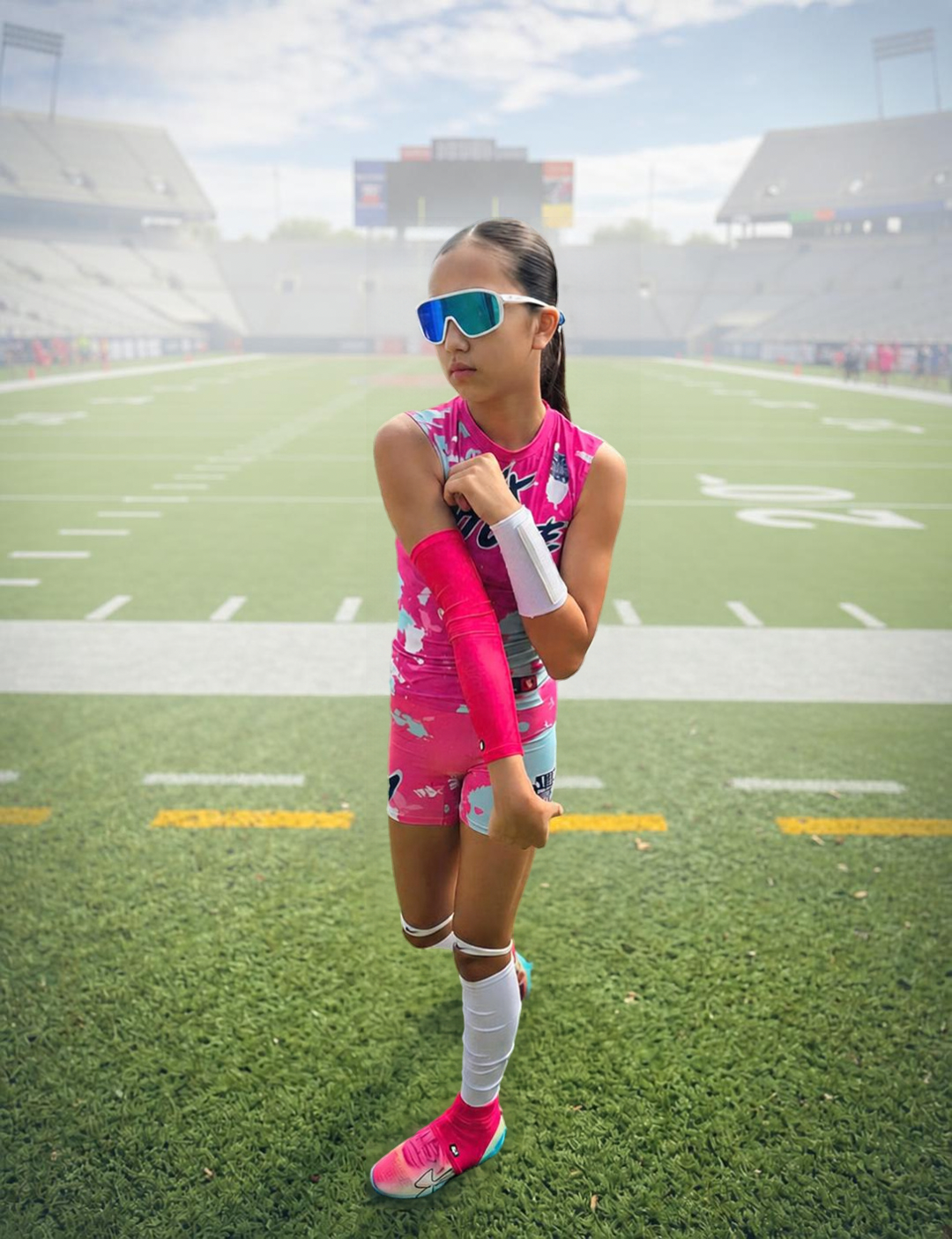 youth flag football quarterback throwing the ball with a pink flag football youth medium arm sleeve