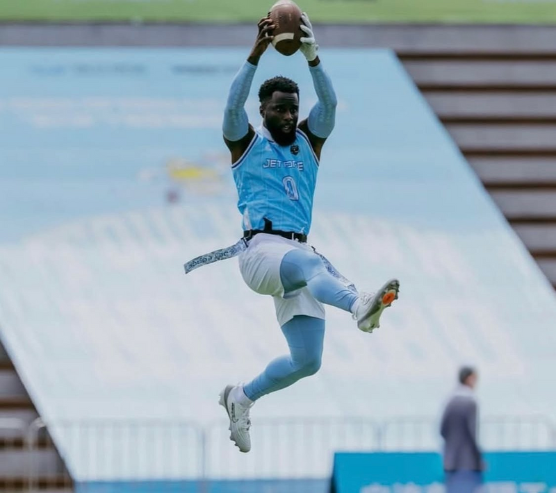 athlete wearing compression grip arm sleeves catching a football