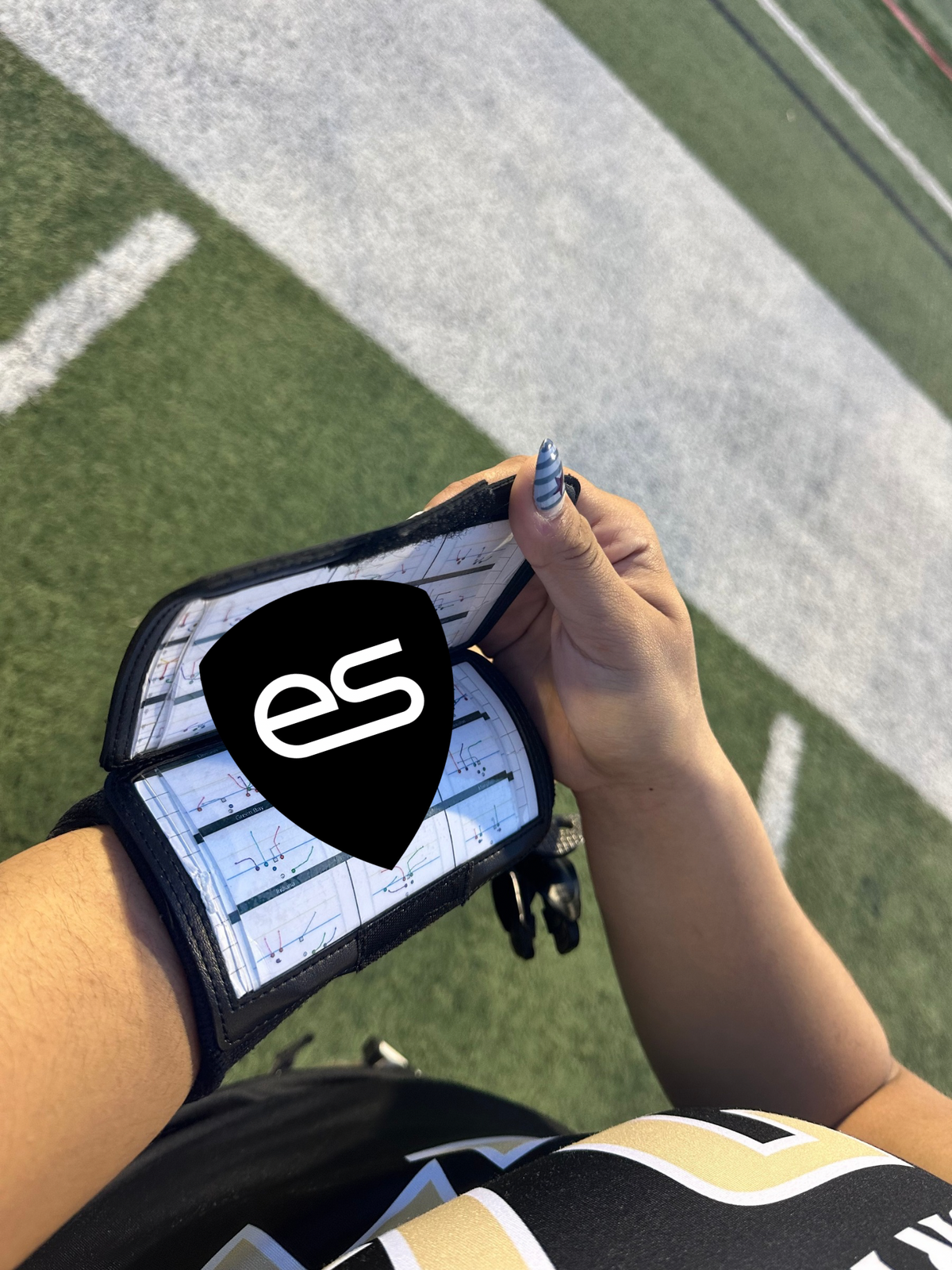 Female flag football player wearing a white playbook wrist coach
