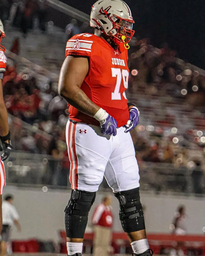 football lineman in a stance wearing the black ams compression leg sleeve in the game